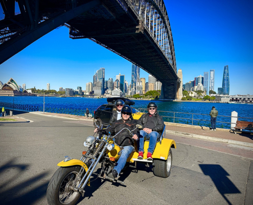 Couple on a trike tour near a Sydney bridge